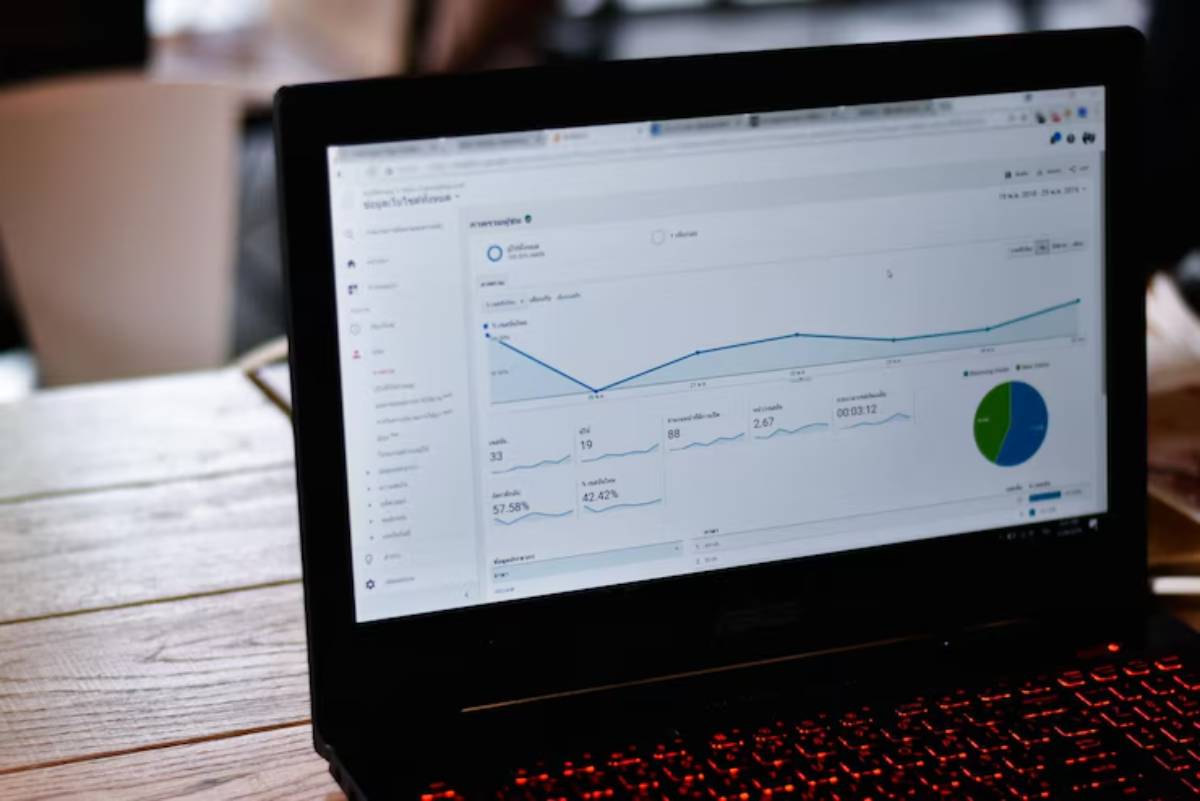 A laptop screen displays analytical data with graphs and statistics in an office setting, showcasing digital performance insights.