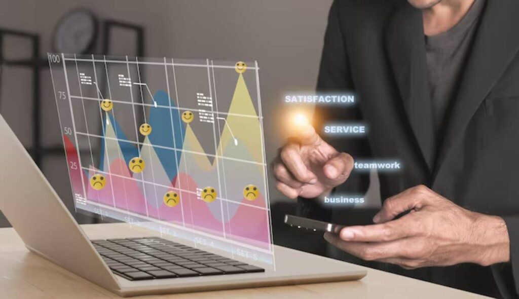 Man interacts with a holographic line graph displaying various emotions. Keywords like 'satisfaction' and 'service' float beside a laptop screen.