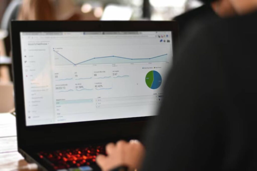 A person analyzing website analytics on a laptop, displaying graphs and data metrics on engagement and audience statistics.