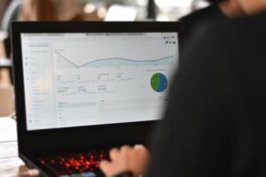 A person analyzing website analytics on a laptop, displaying graphs and data metrics on engagement and audience statistics.