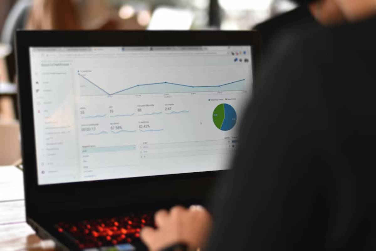 A person analyzing website analytics on a laptop, displaying graphs and data metrics on engagement and audience statistics.