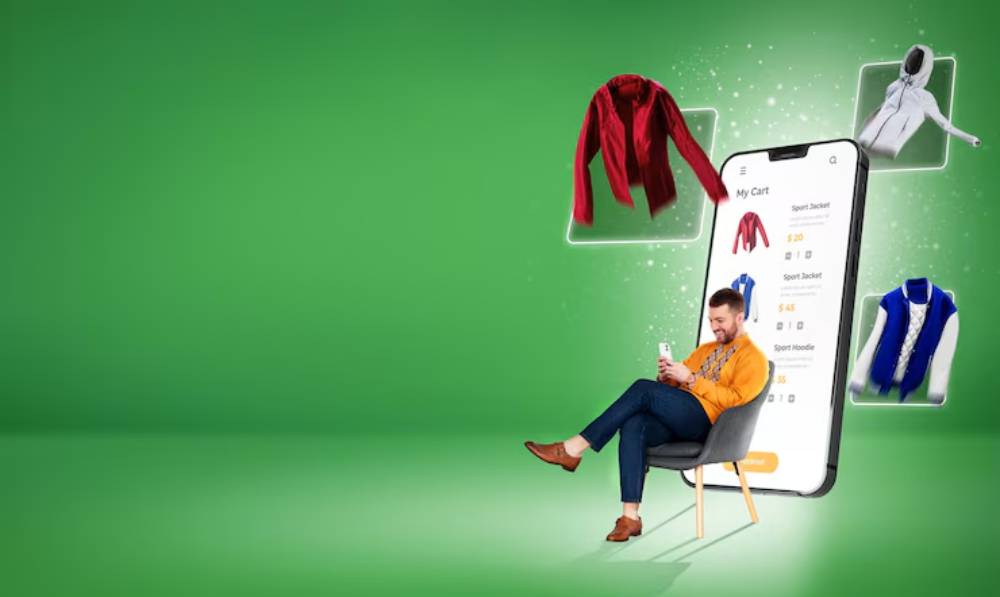 A person sits on a chair, holding a phone, with various clothing items floating around a large smartphone screen on a green background.