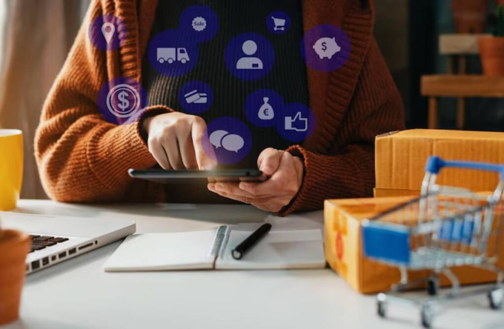 A person in a cozy sweater uses a tablet, surrounded by shopping-related icons, boxes, and a small shopping cart.