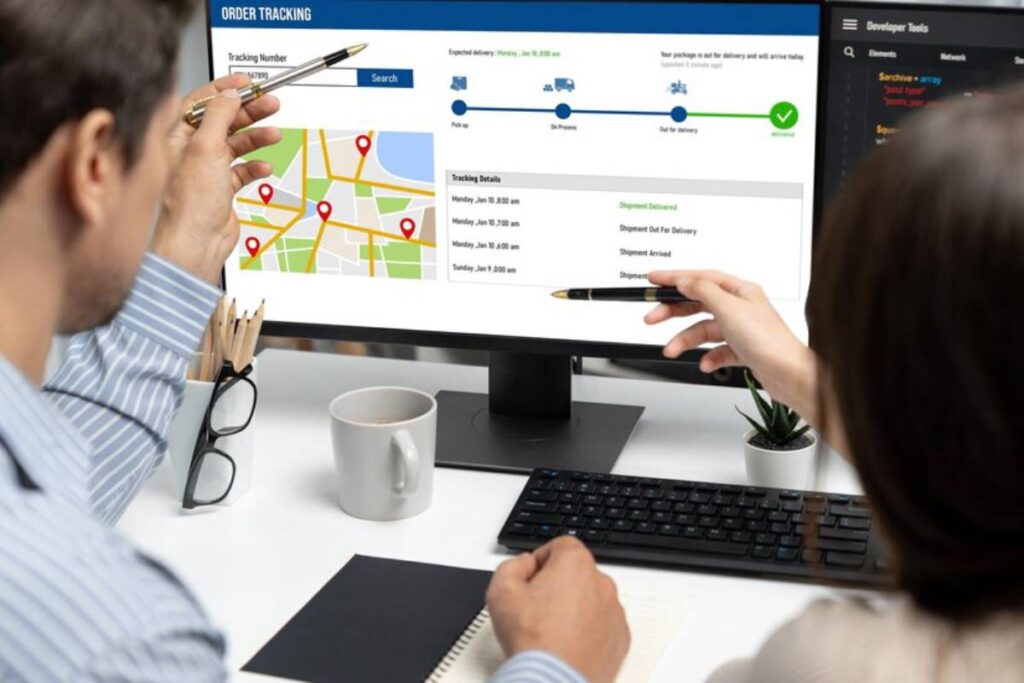 Two people tracking an order on a computer screen, showing a map with delivery locations and shipment status updates.